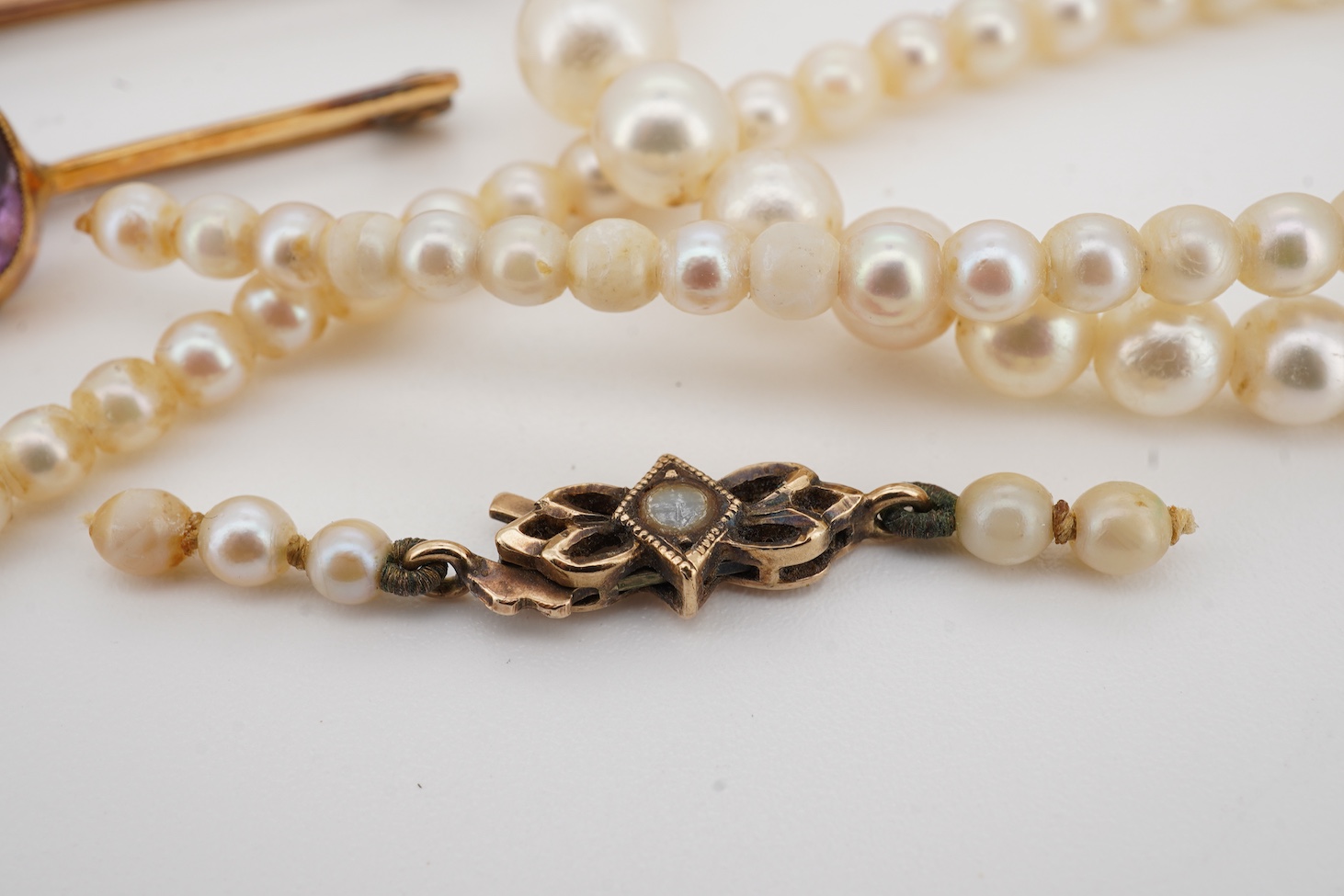A 9ct owl bar brooch, with cabochon eyes, 50mm, a 1960's 9ct gold and amethyst set bar brooch, an 18ct and amethyst set bar brooch, a cameo brooch(a.f.) and a cultured pearl necklace with 9ct gold clasp.